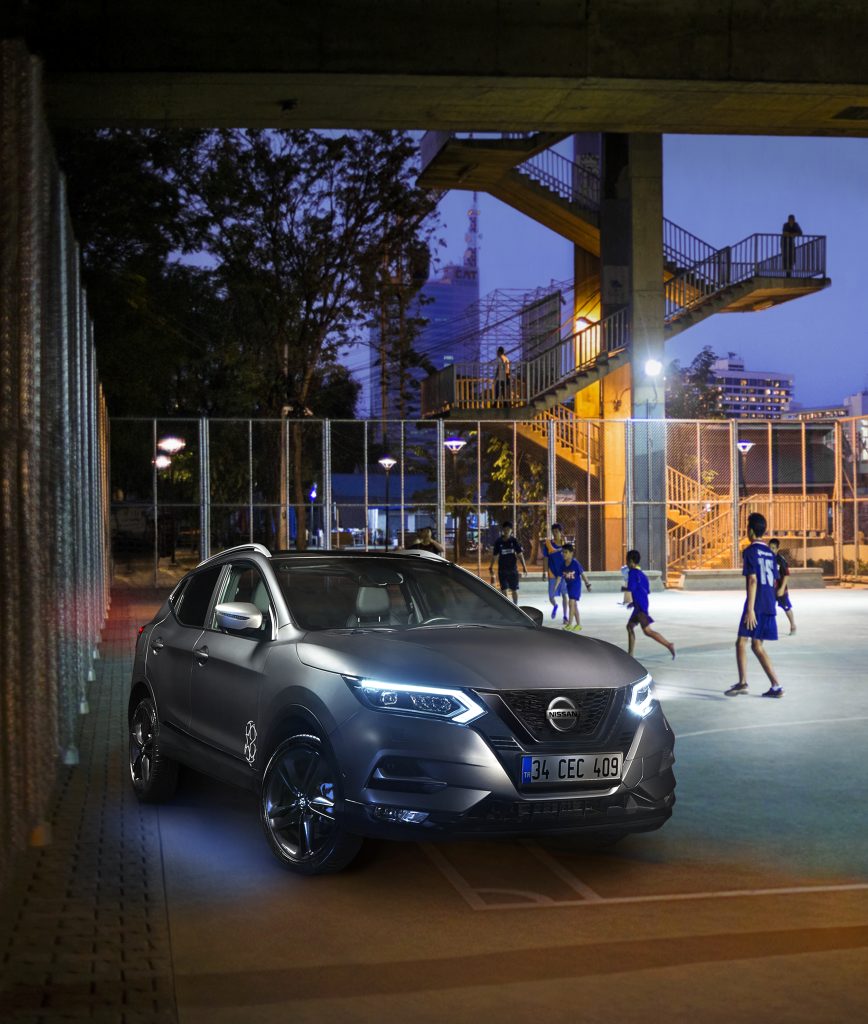 A game of soccer at dusk beneath a bridge in Bangkok, Thailand.